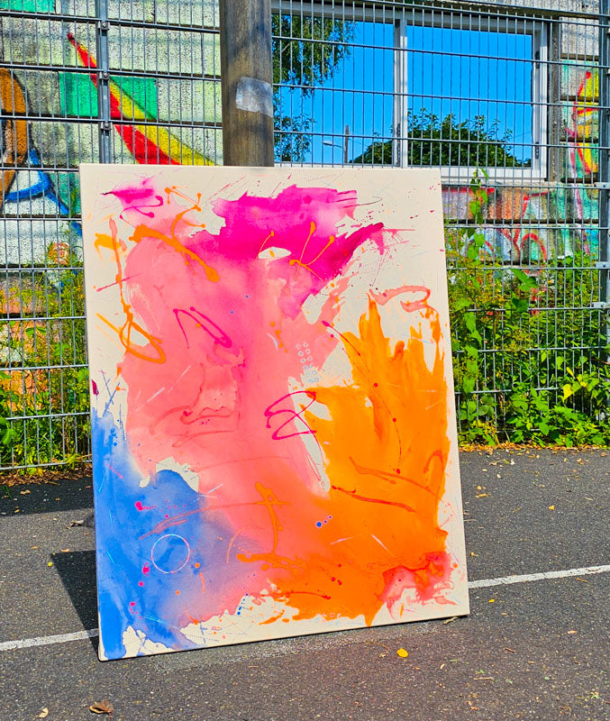 Farbenfrohes Kunstwerk mit Pink, Orange und Blau vor einer urbanen Kulisse, reflektiert den Sommergeist.