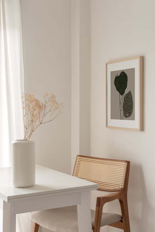 Boho Esszimmer mit schlichtem botanischem Kunstdruck an der Wand auf dem zwei Monstera Blätter gezeichnet sind