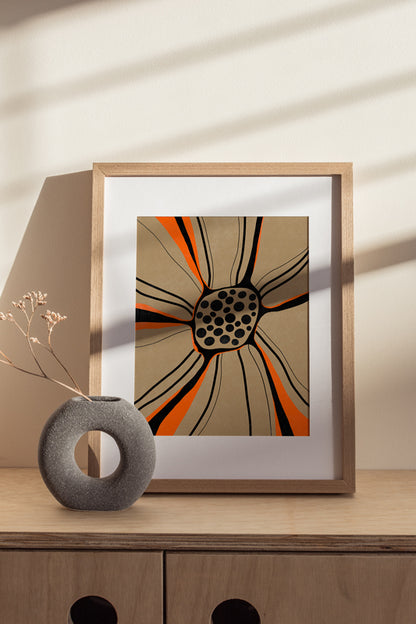 Gerahmter Kunstdruck mit abstrakter Blume in Orange und Schwarz im Risografie Look auf Holzkommode im warmen Interior